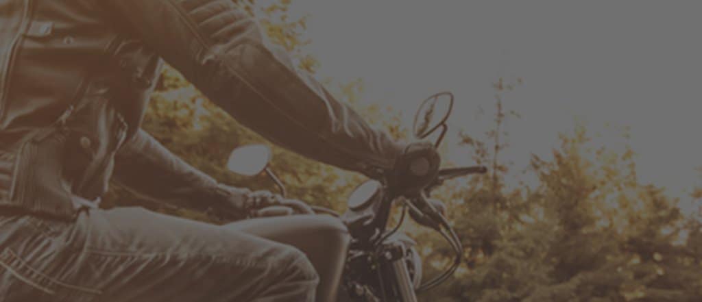 Biker on a motorcycle with a leather jacket and jeans