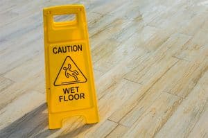 Caution wet floor sign yellow on wooden floor