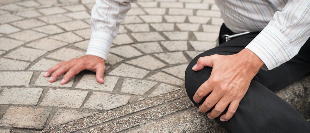 man on floor holding knee in pain