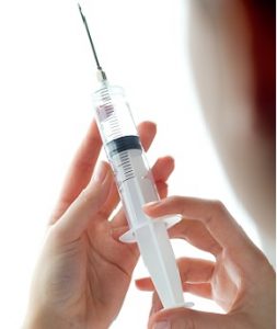 Woman hand holding syringe. Isolated on a white.