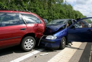 Rear end collision of two cars with a medical professional speaking to the driver of the read vehicle.