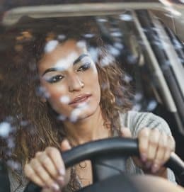 Beautiful young arabic woman inside a nice white car looking through the window. Arab girl wearing casual clothes.