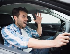 Young man experiencing road rage in his car