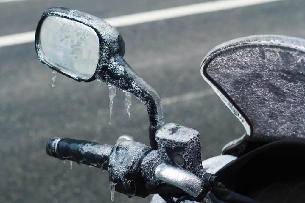 closeup of frozen motorcycle windshield and rear mirror