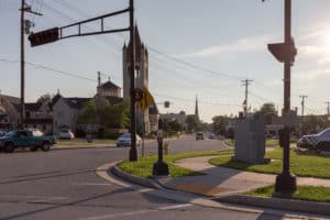 Urban crossroad in downtown Waukesha, a small town in Wisconsin, USA. A church can be seen in the left side of the street. Dusk sunlight caste from the right.