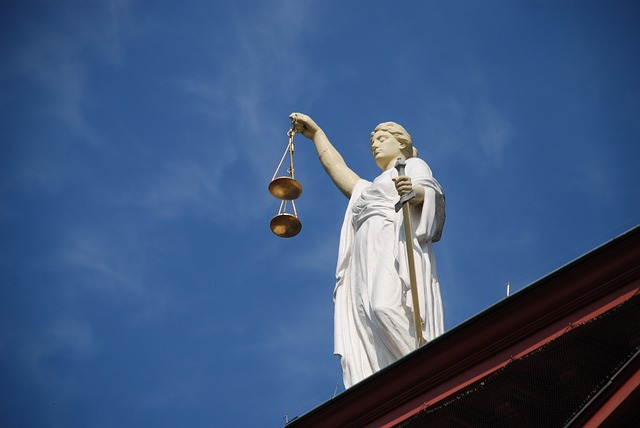 lady justice statue with a clear blue sky behind