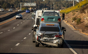 A tow truck tows a damaged car away after a truck accident.