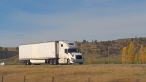 A white 18-wheeler barrels down a desolate highway while other drivers wonder: How do truck accident lawsuits work?