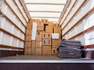 The back of a cargo truck is open, displaying loose cargo, leading one to wonder: What happens if loose cargo causes an accident?